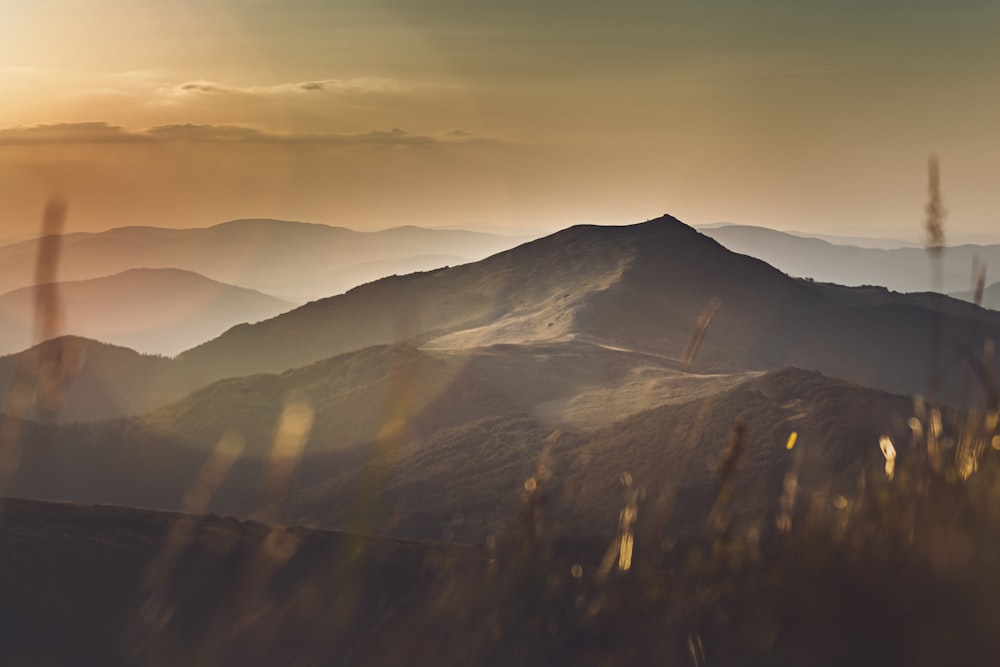 brown and green mountains under white clouds during daytime