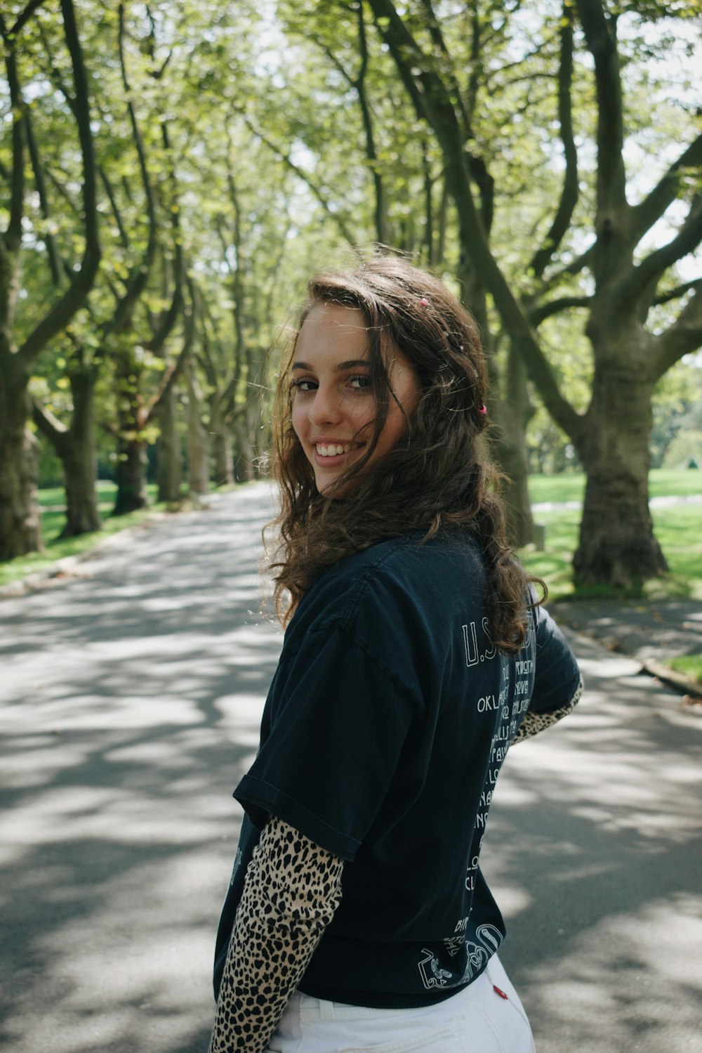 woman in black shirt standing on road during daytime