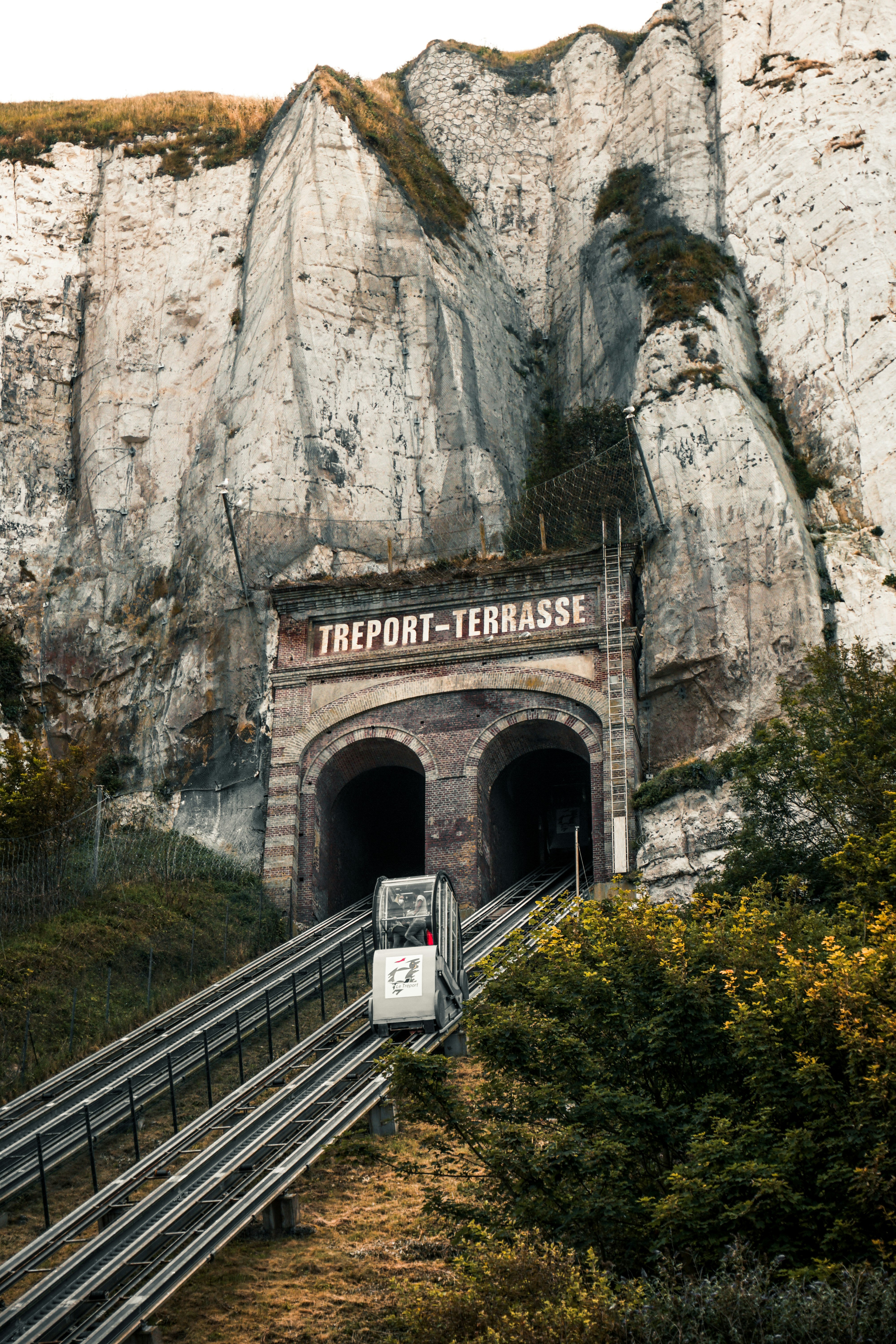 white train on rail near gray rocky mountain during daytime