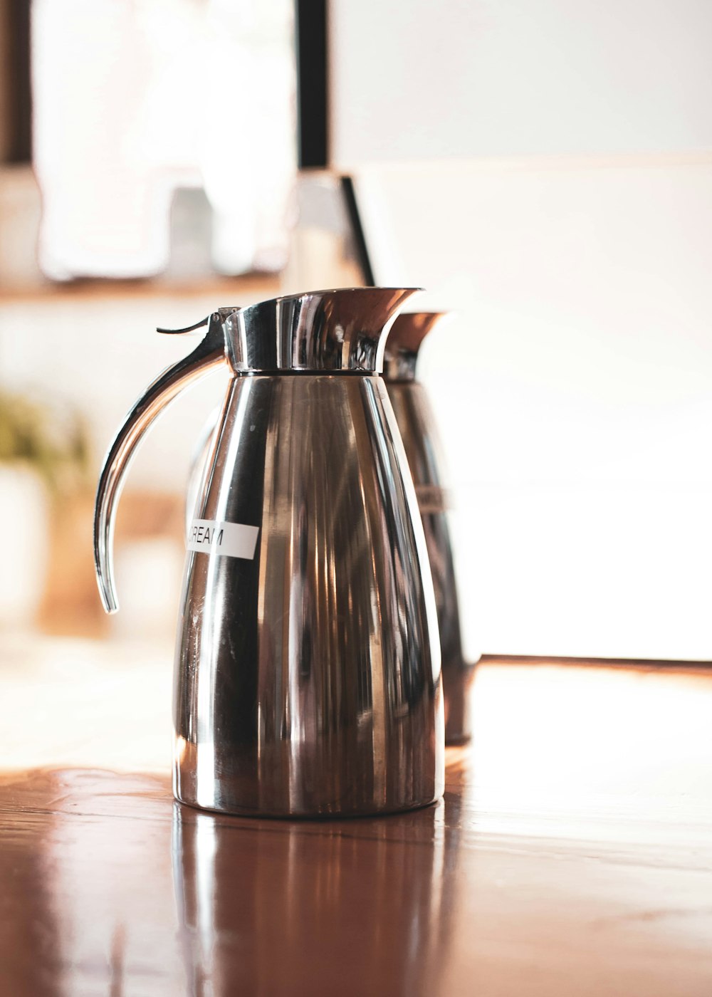 black and silver pitcher on brown wooden table