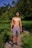 topless man in gray shorts standing on green grass field during daytime