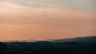 A serene landscape featuring rolling hills at sunset.