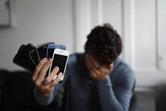 man in blue long sleeve shirt holding black and white box
