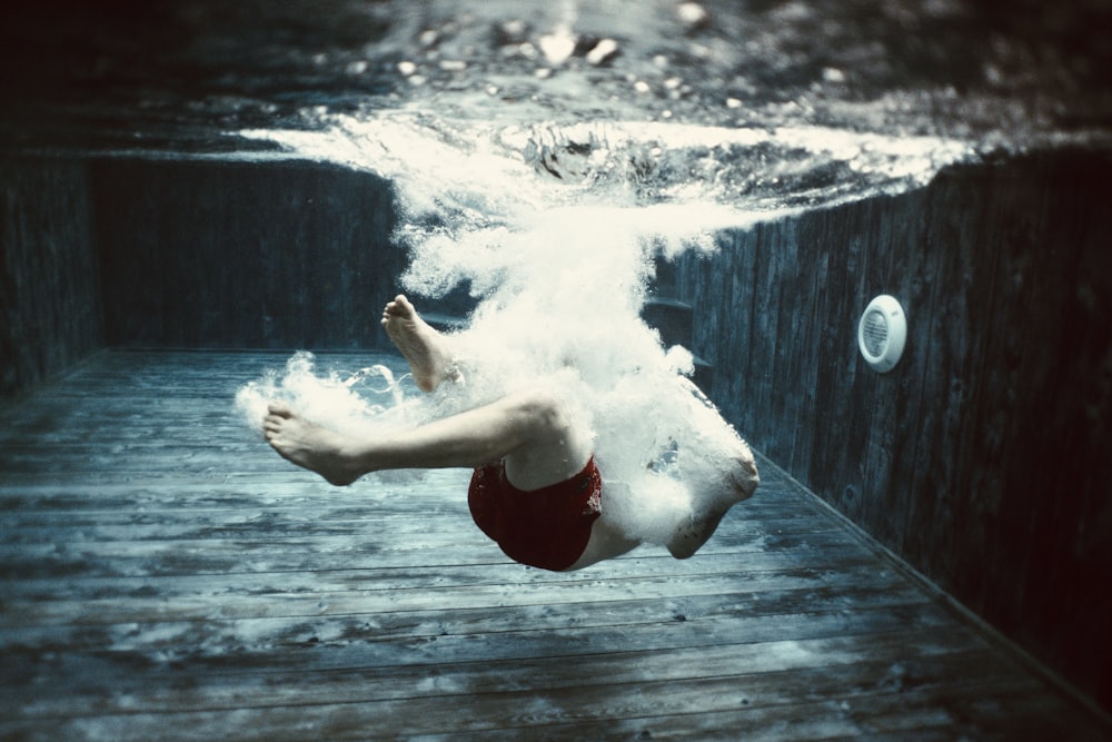 woman in red shorts jumping on water