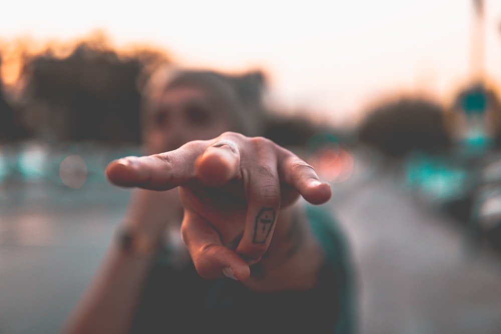 person doing heart hand sign