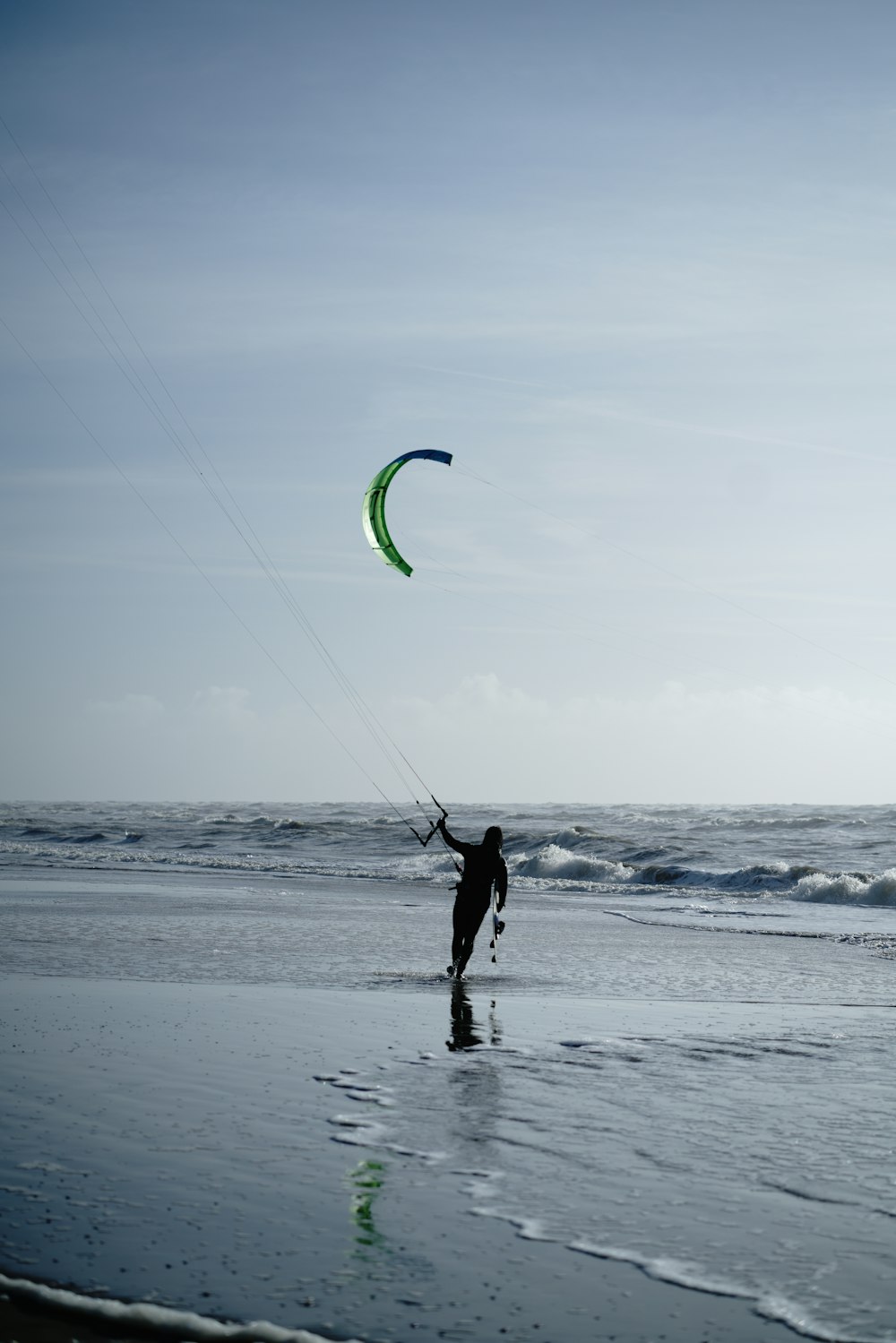 silhueta do homem que segura o kitesurf no mar durante o dia
