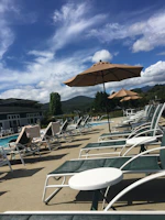 Sparkling swimming pool area with loungers and umbrellas on a sunny day.