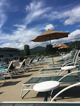 Hotel pool area with sun loungers and families enjoying the water