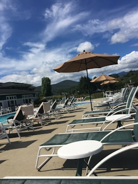 A large swimming pool surrounded by sun loungers and umbrellas.