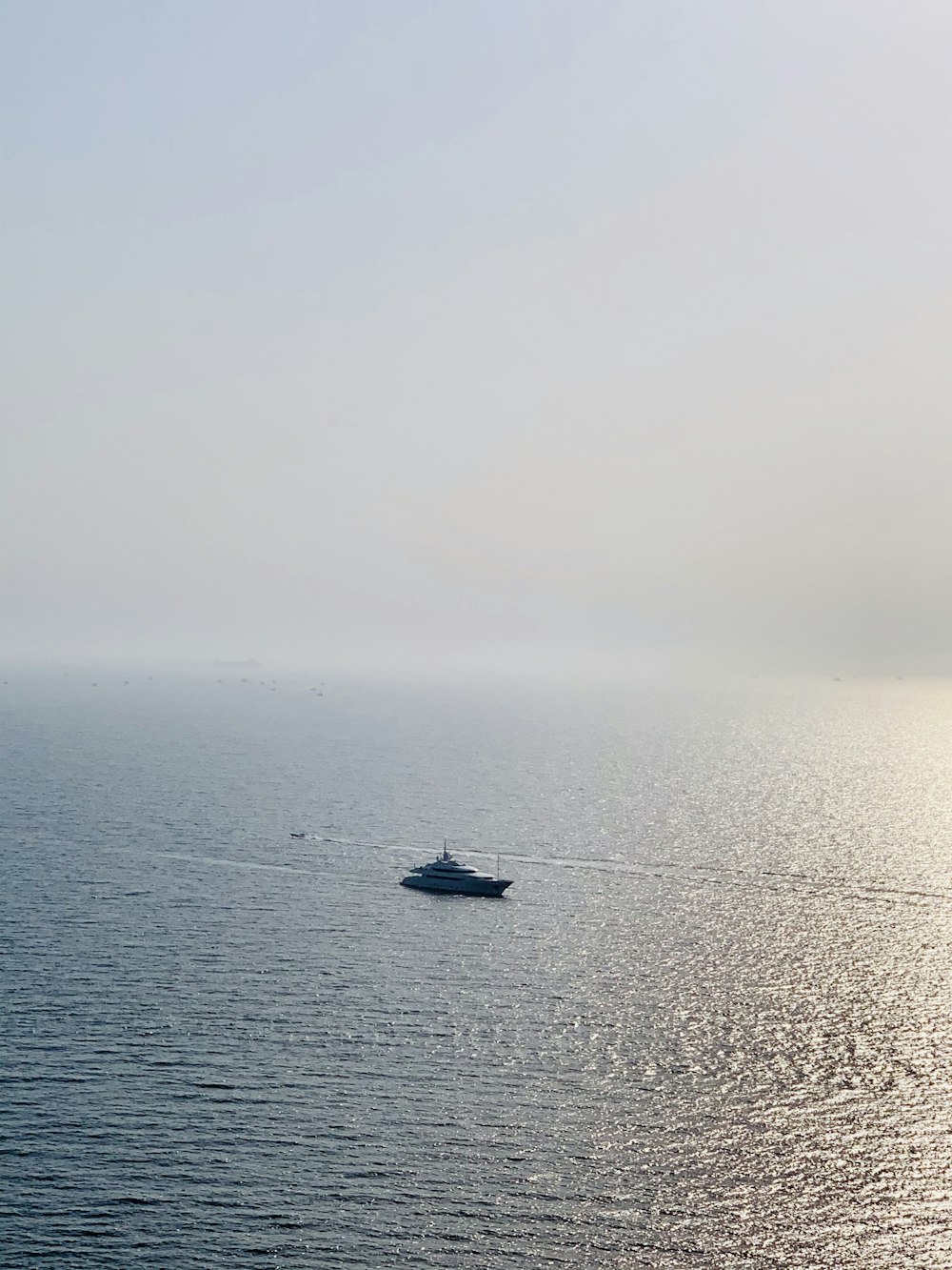 Schwarzes Boot auf See unter weißem Himmel tagsüber