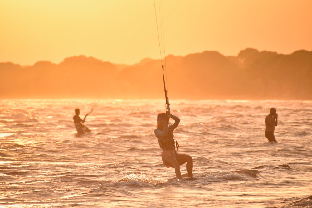 a group of people riding surfboards on top of a body of water