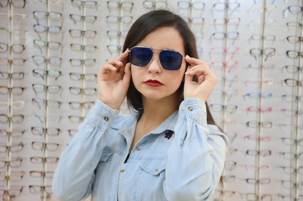 Frau in blauer Jeansjacke mit blauer Sonnenbrille