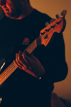 person holding brown acoustic guitar