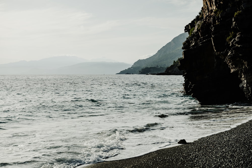 body of water near mountain during daytime