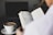 A person reading a guide on a laptop with a cup of coffee beside them.