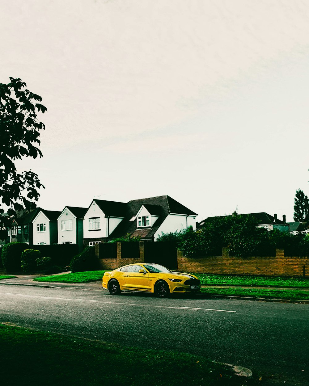 yellow car parked near house during daytime