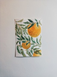Brightly painted papaya-themed canvas artwork hanging on a wall.
