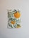 A watercolor painting of orange fruits hanging from green leafy branches. The artwork is mounted on a wall with a light-colored background, highlighting the vibrant colors of the leaves and fruits.
