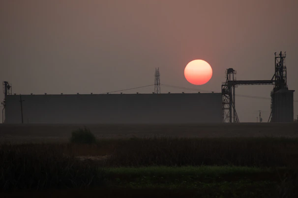 An industrial site with energy infrastructure under a clear sky at sunset.