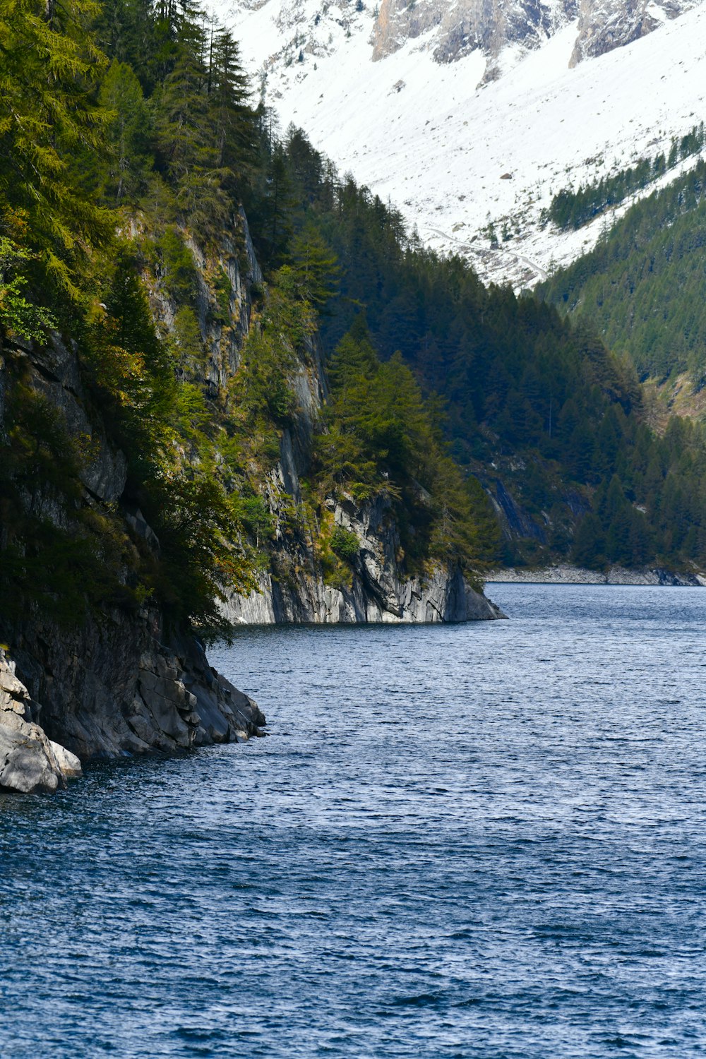 green and brown mountain beside body of water during daytime