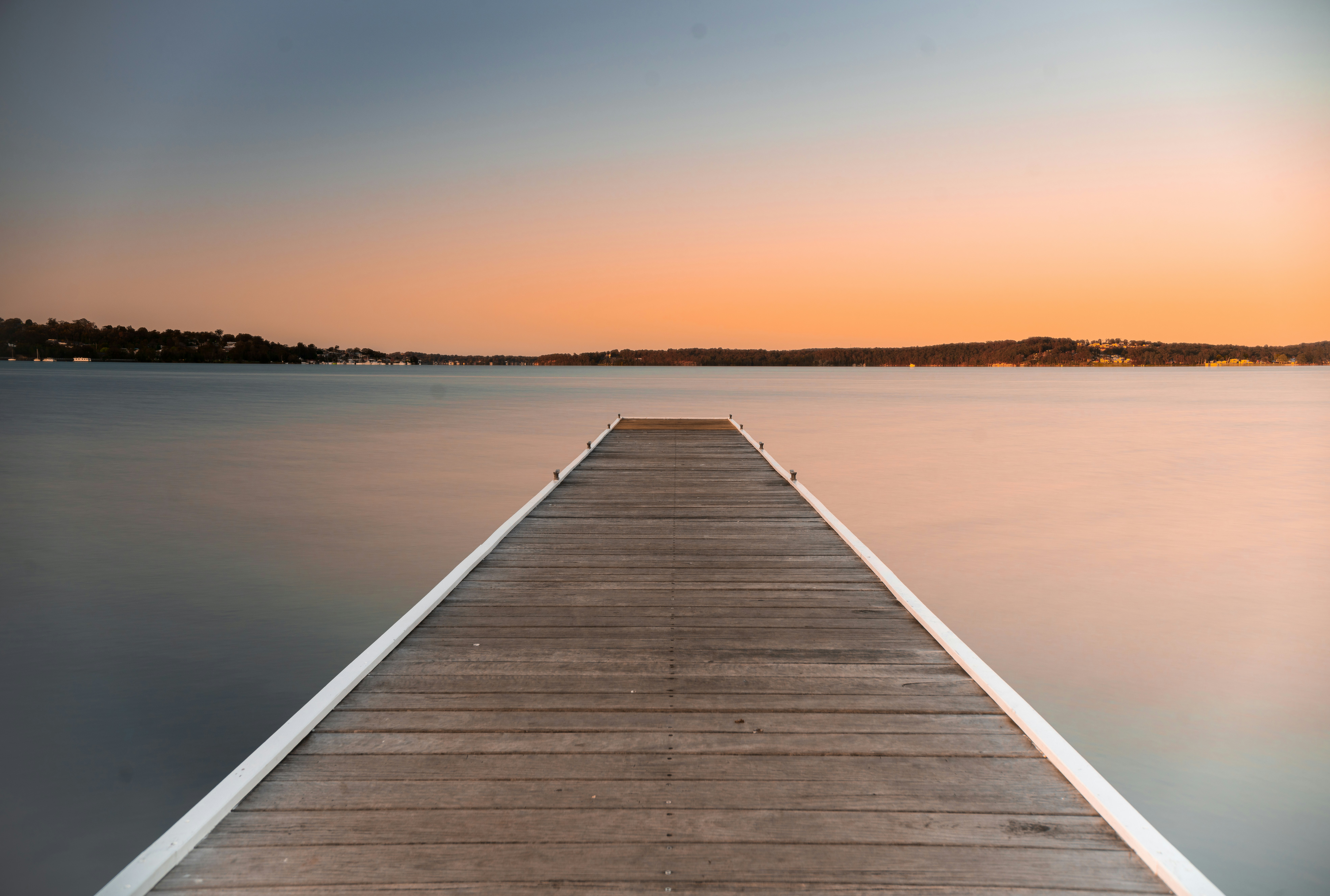 brown wooden dock on beach during sunset
