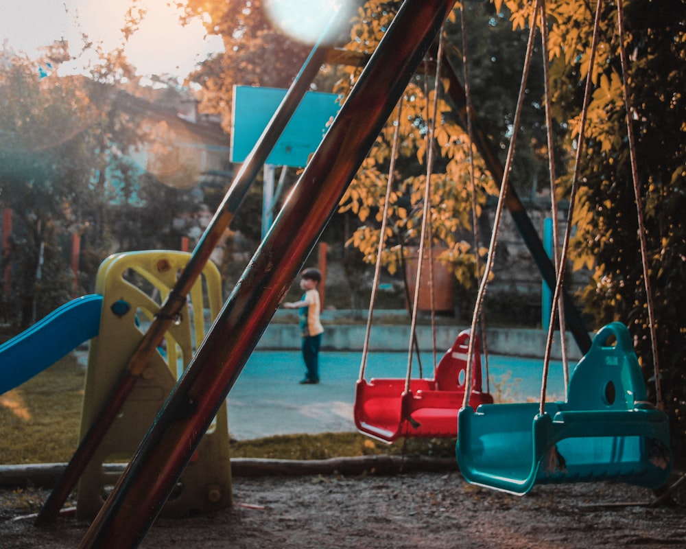 red swing on body of water during daytime