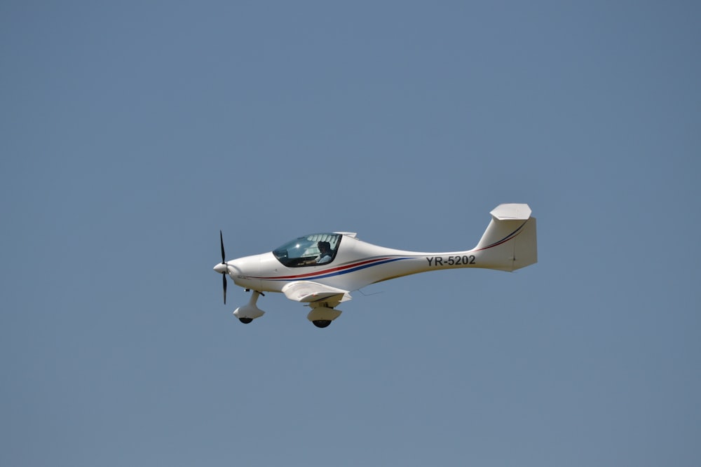 white and green plane flying in the sky