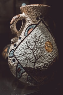 Delicate ceramic vase with a matte finish, decorated with a simple hand-painted wave pattern.