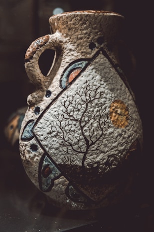 A colorful, hand-painted clay vase showcasing artisan brushwork.