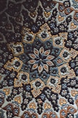 A detailed handcrafted ceramic tile featuring traditional Persian geometric designs in rich blues and golds.