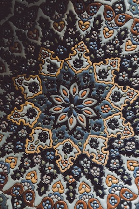 A detailed handcrafted ceramic tile featuring traditional Persian geometric designs in rich blues and golds.
