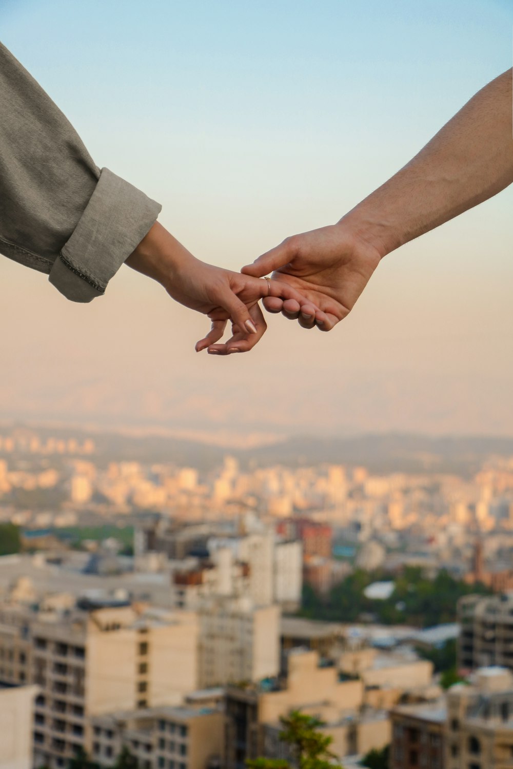 person in gray long sleeve shirt holding hands of person in gray long sleeve shirt during