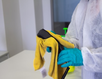 person in white robe holding black and yellow umbrella