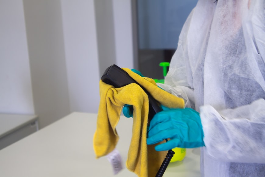  Person wiping telephone with a microfiber cloth
