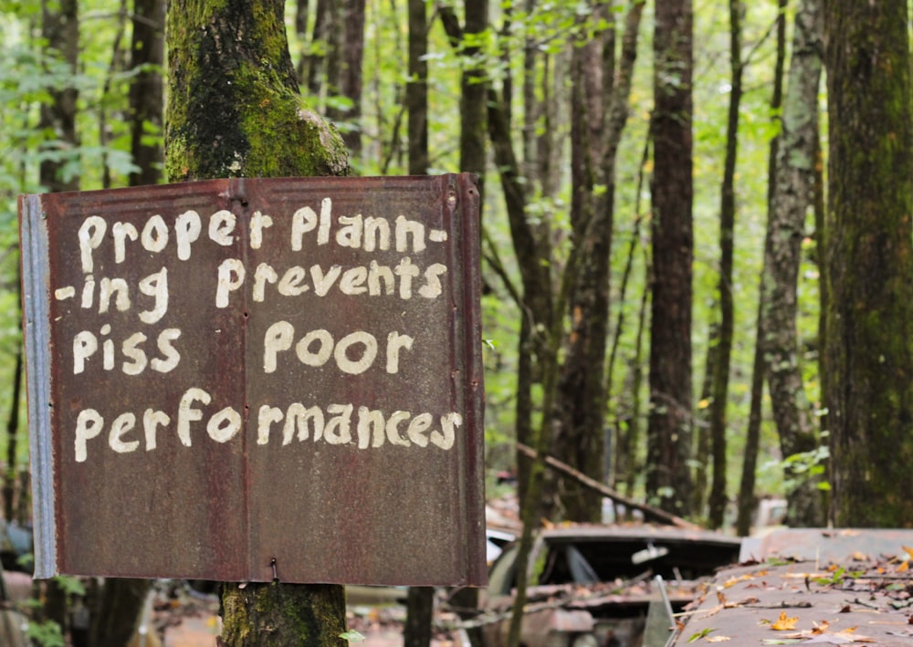 brown wooden signage near green trees during daytime