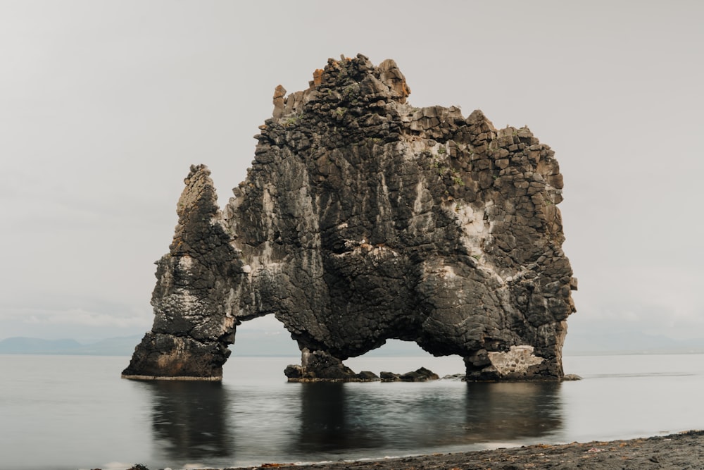 brown rock formation on body of water during daytime