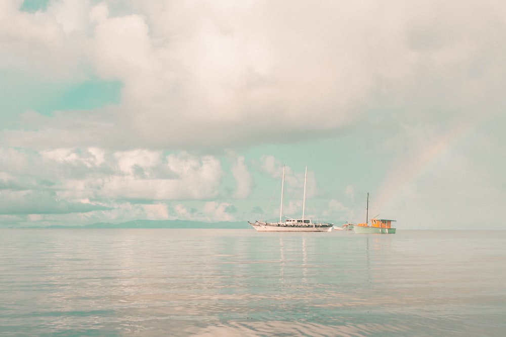 white boat on sea under white clouds during daytime