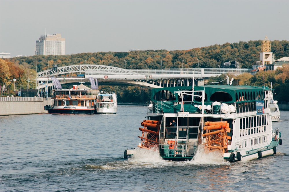 a large boat traveling down a river next to a bridge