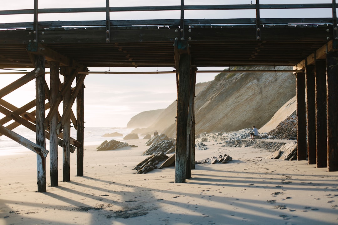 brown wooden bridge over the white sand during daytime