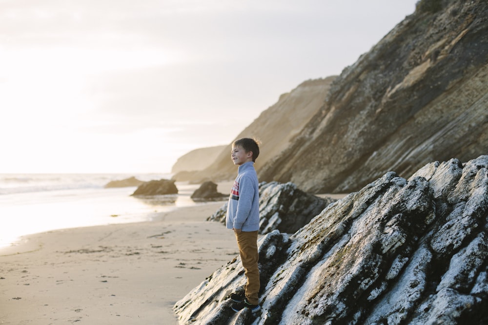 man in blue dress shirt standing on brown rock formation during daytime