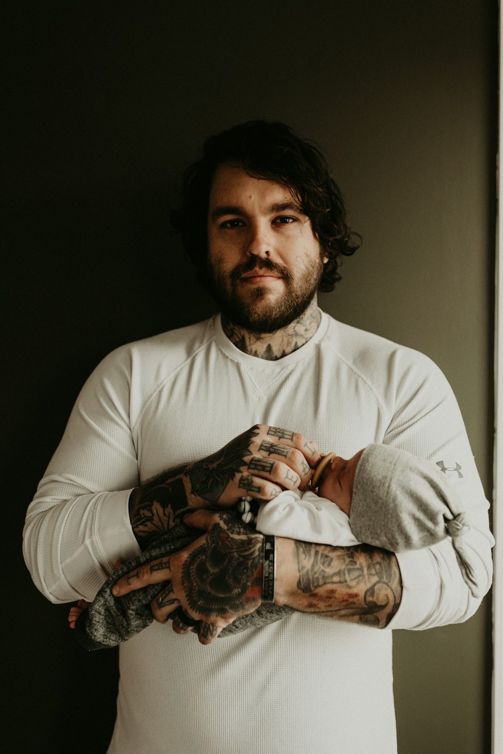 Hombre en camiseta blanca de cuello redondo con tatuaje en el brazo