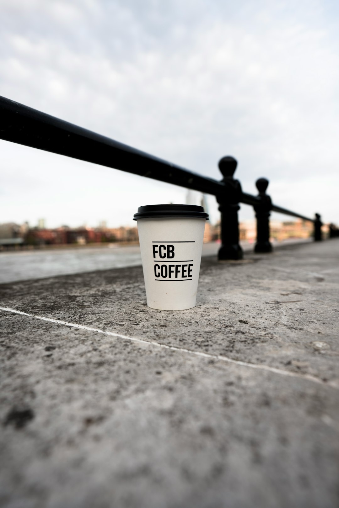 white and black disposable cup on gray concrete floor