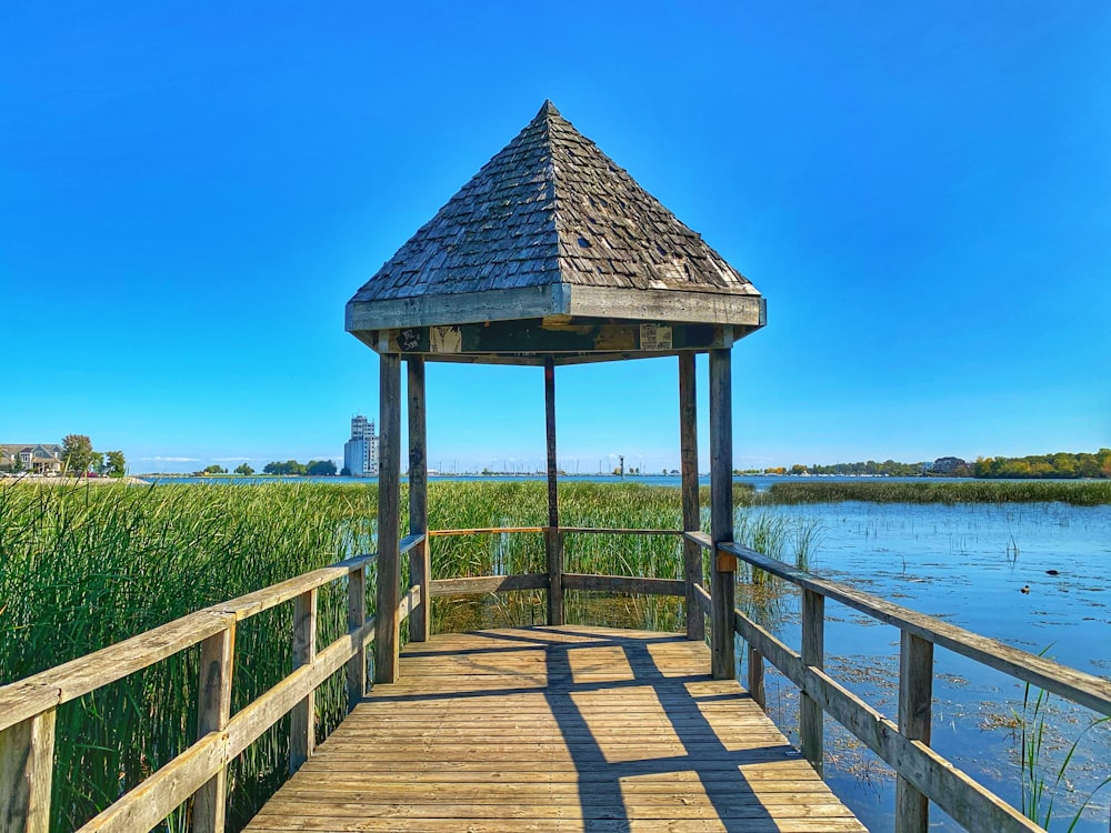 a small wooden gazebo sitting on top of a wooden bridge