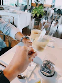 Guests laughing and clinking glasses during a wedding reception with subtle white minimalist decor.