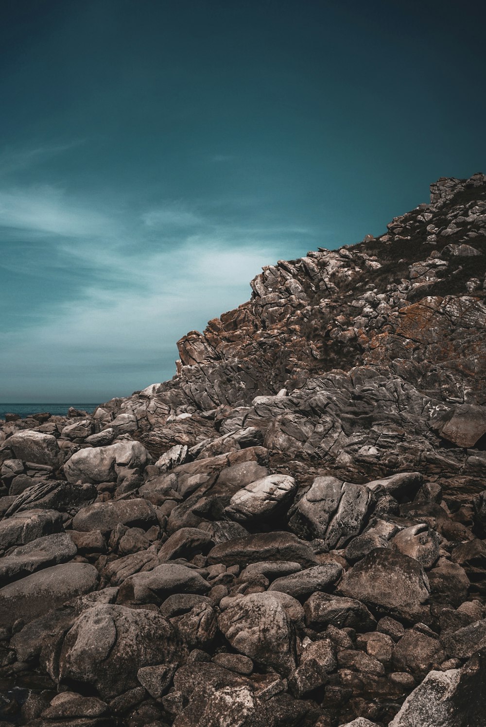 montanha rochosa marrom perto do corpo de água durante o dia