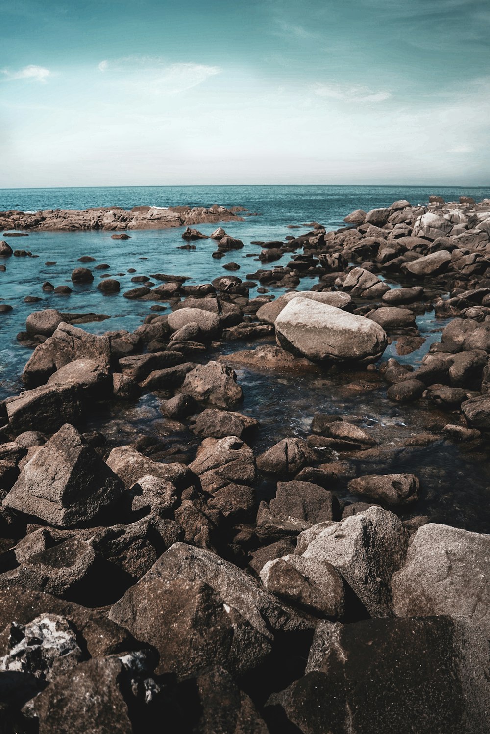 Rocas grises y negras en la orilla del mar durante el día