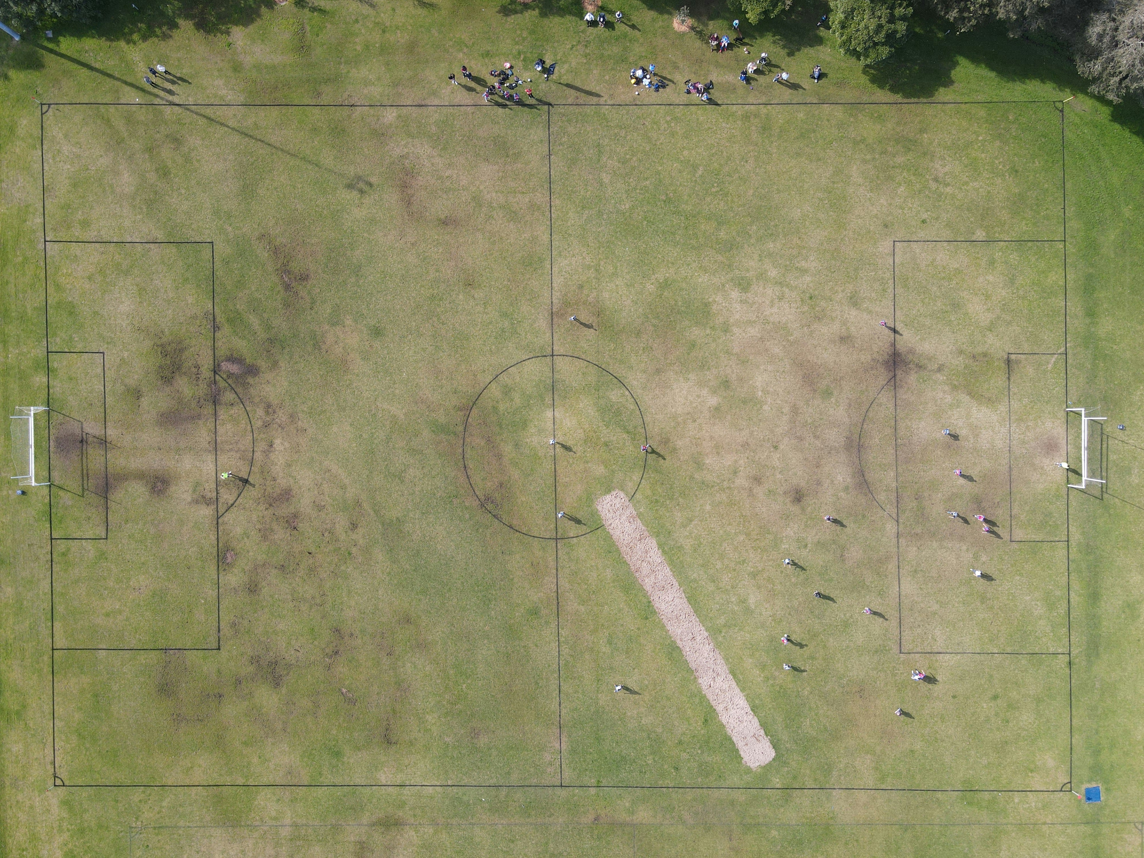 Vista aérea de un partido de fútbol con ambos equipos en campo