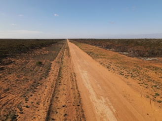 brown dirt road under blue sky during daytime