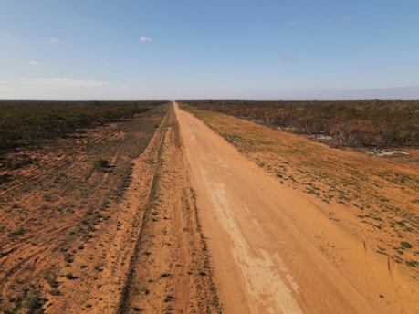 brown dirt road under blue sky during daytime