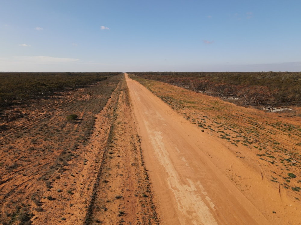 brown dirt road under blue sky during daytime